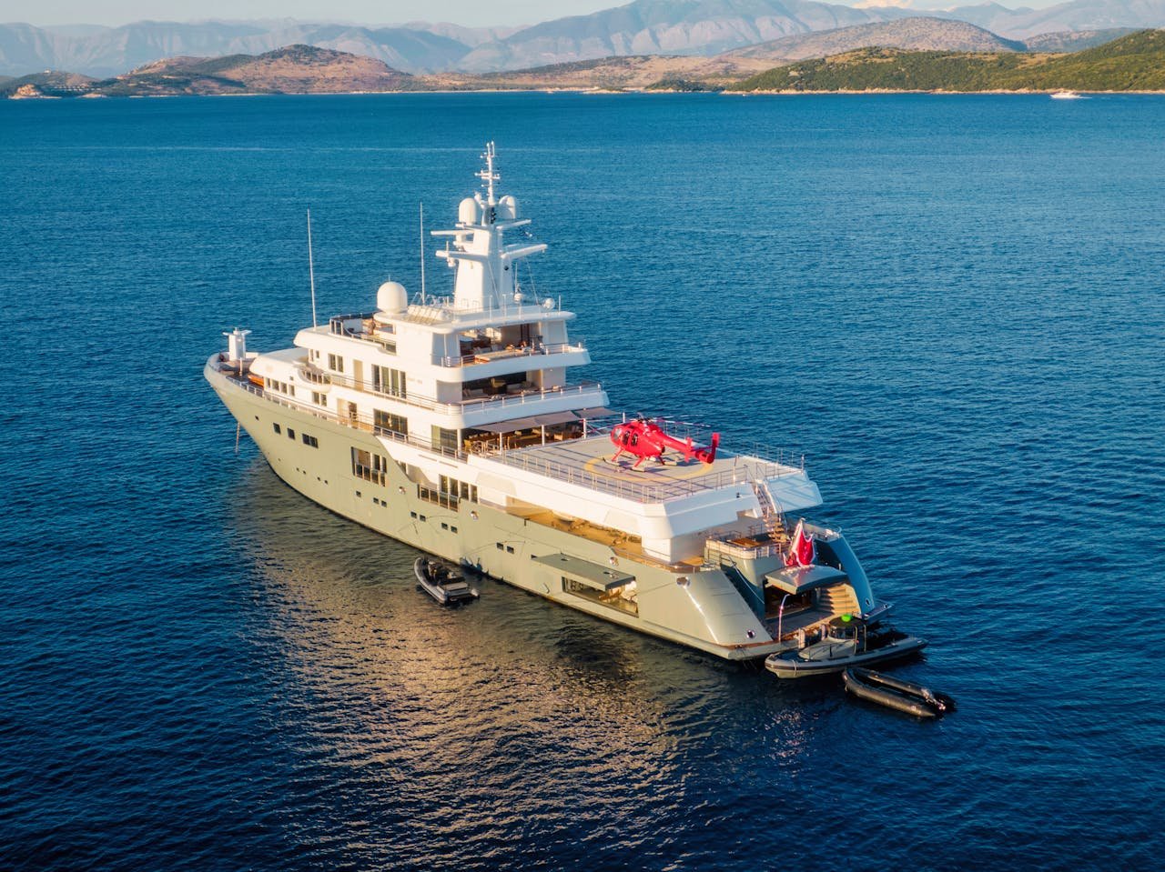 A luxurious yacht with a helipad in the calm waters of the Ionian Sea, near Corfu, Greece.