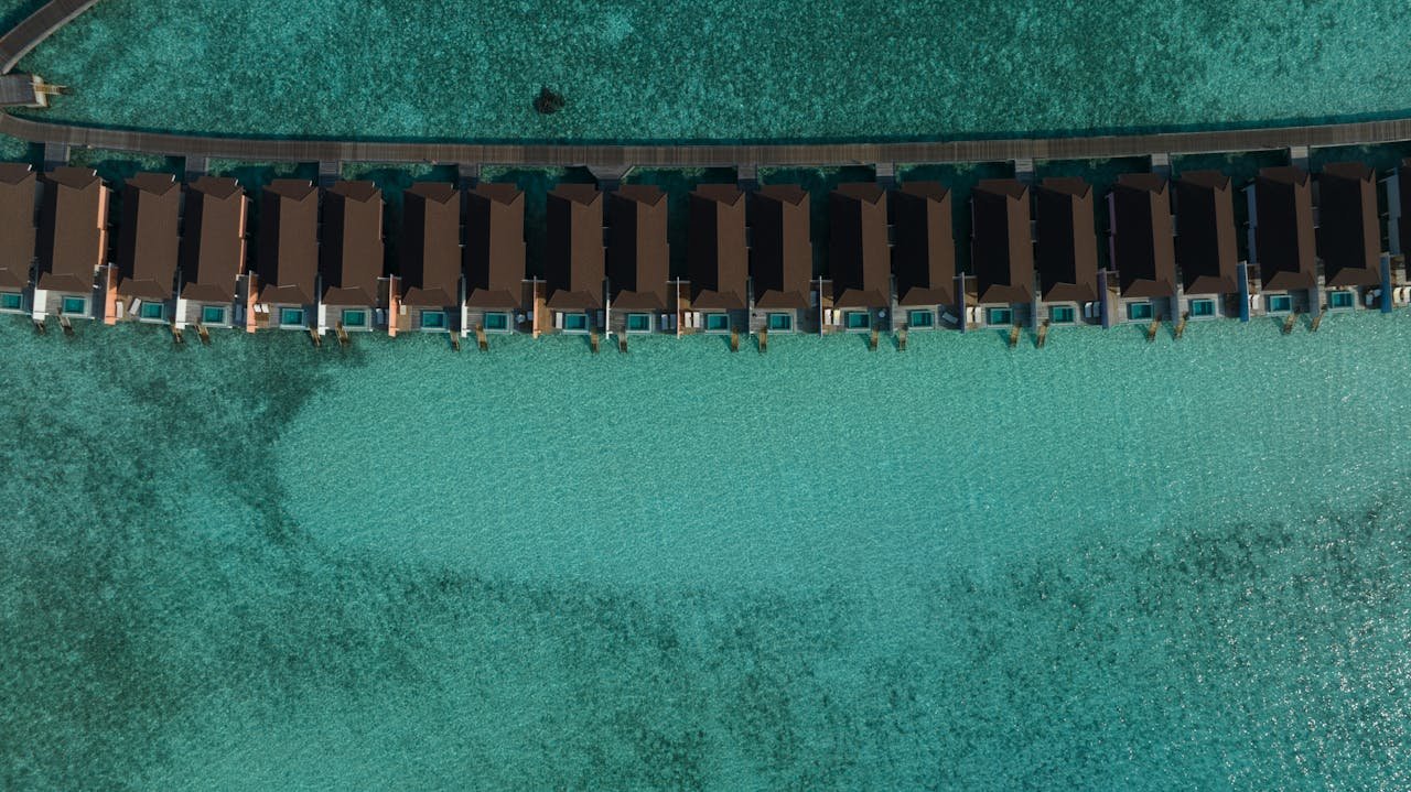 services-01 Stunning aerial view of overwater villas in turquoise waters of the Maldives.